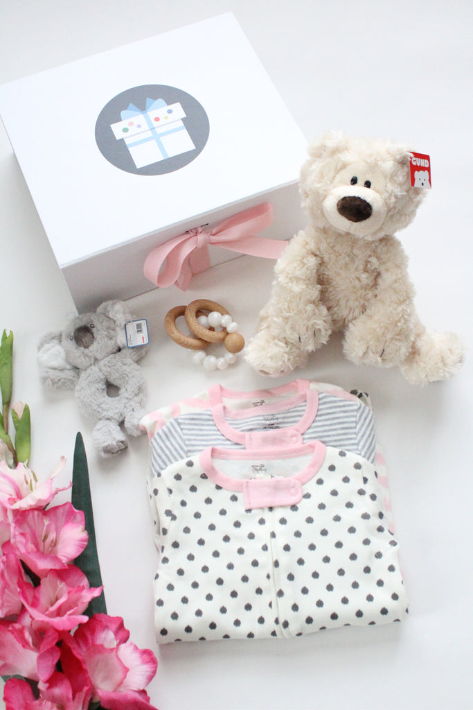 Baby girl gift  featuring a plush bear, pearl wooden and silicone teether and 3 piece sleepers. Makes a beautiful gift.