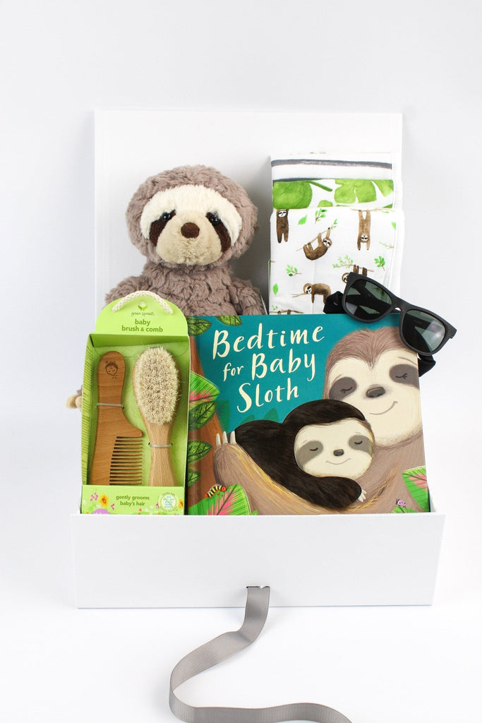 This adorable gender neutral sloth themed baby gift box is a box full of unique and essential baby needs. Featuring Mary Meyer's Grey Putty Stuffed Sloth Animal , a Bedtime for Baby Sloth Board book ,a set of wooden brush and comb, black Sunglasses, a 3 Piece Burp Cloths all in a gift box with handwritten card.