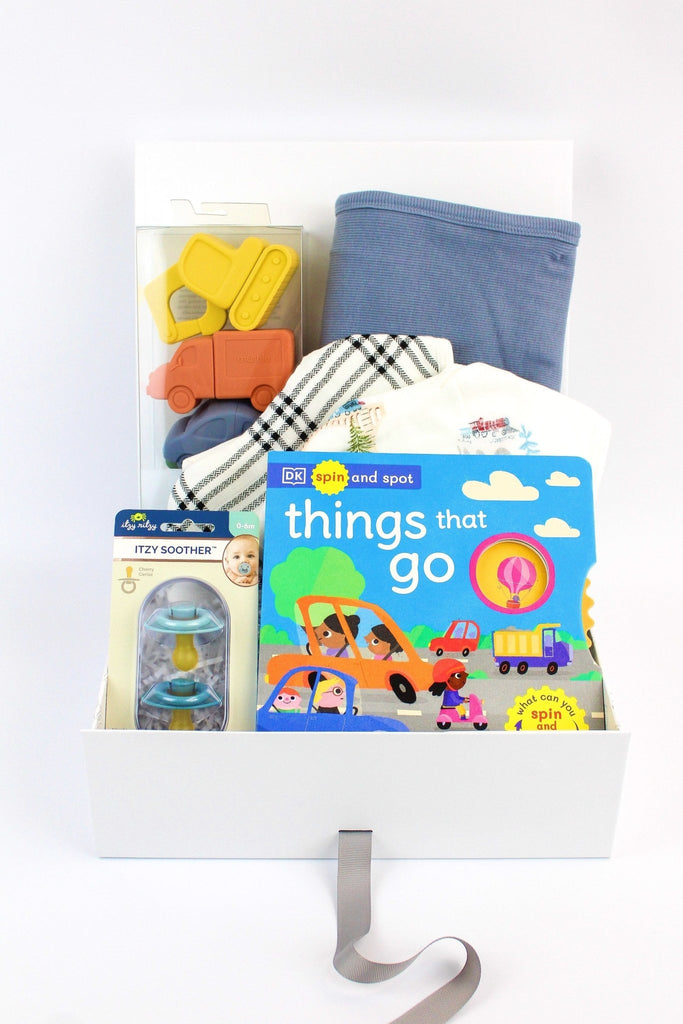 Things That Go Baby Gift Box is a fun and practical baby boy gift. Featuring Spin and Spot: Things That Go, a delightful and interactive board book, a Ribbed Baby Blanket crafted out of organic cotton, a vehicles bath play set that includes a helicopter, car, truck and excavator. 2 natural rubber pacifier set and a train themed bib.